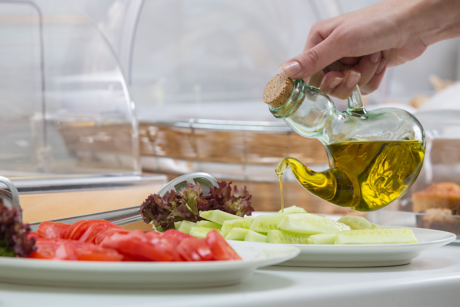 Pooring olive oil on salad