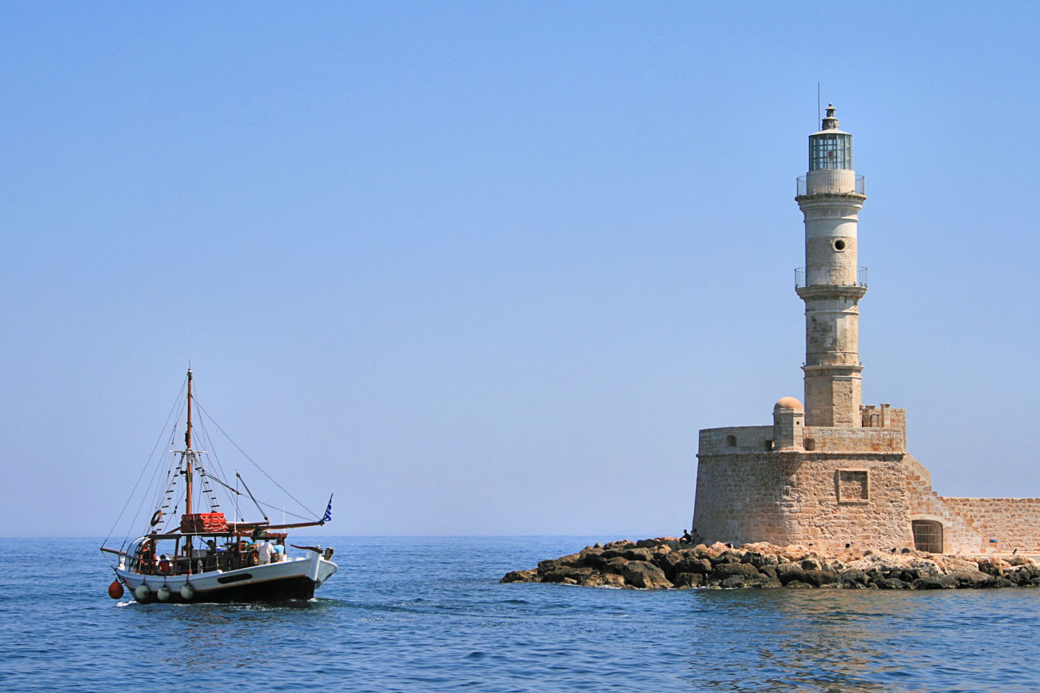 Chania Lighthouse with a small boat passing by
