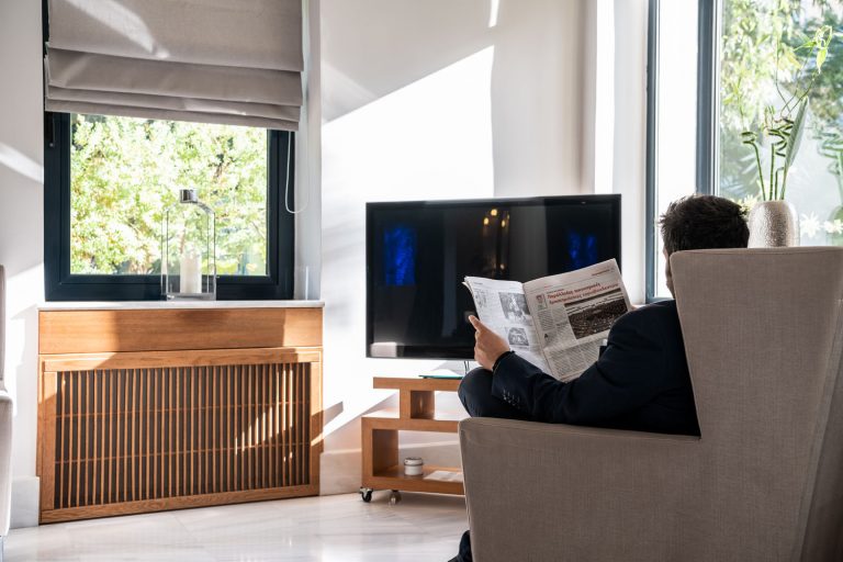 man reading newspaper inside the lobby